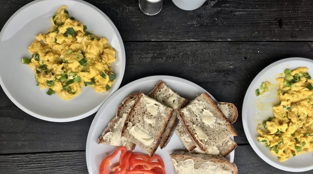 Jajecznica z wiejskich jajek przyrządzona ze słoniną wędzoną na zimno podana ze skwarkami z niej wytopionymi i posypana świeżą dymką.