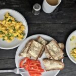 Jajecznica z wiejskich jajek przyrządzona ze słoniną wędzoną na zimno podana ze skwarkami z niej wytopionymi i posypana świeżą dymką.