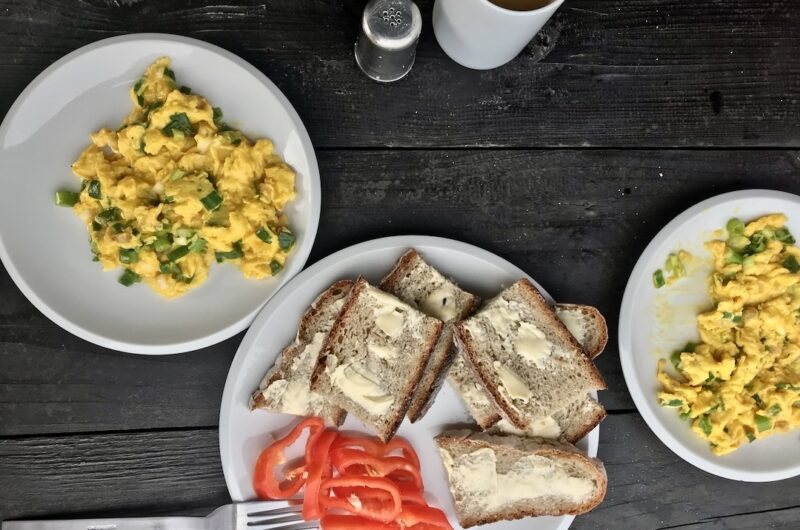 Jajecznica z wiejskich jajek przyrządzona ze słoniną wędzoną na zimno podana ze skwarkami z niej wytopionymi i posypana świeżą dymką.