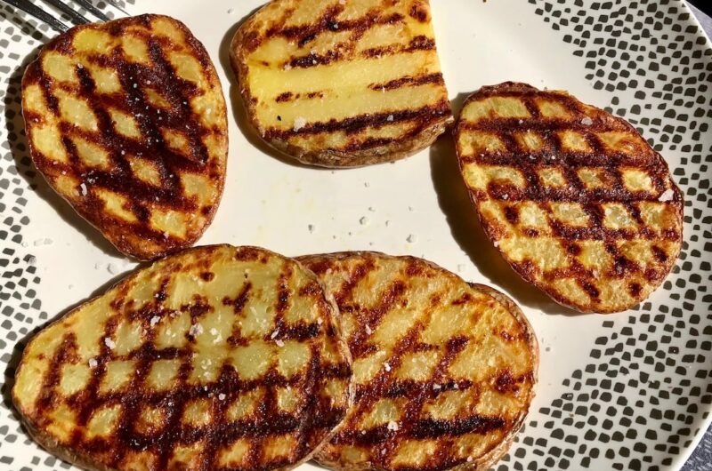 Ziemniaki z grilla przyrządzone z talarków wykrojonych z ziemniaków, grillowanych na ruszcie i podanych z masłem czosnkowym, solą morską i suszonym oregano.