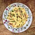 Jajecznica na boczku, czyli jajka rozkłócone i smażone razem z pokrojonym w drobną kostkę boczkiem surowym wędzonym wzbogacona smakiem dymki.