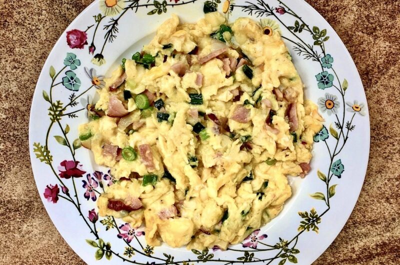 Jajecznica na boczku, czyli jajka rozkłócone i smażone razem z pokrojonym w drobną kostkę boczkiem surowym wędzonym wzbogacona smakiem dymki.