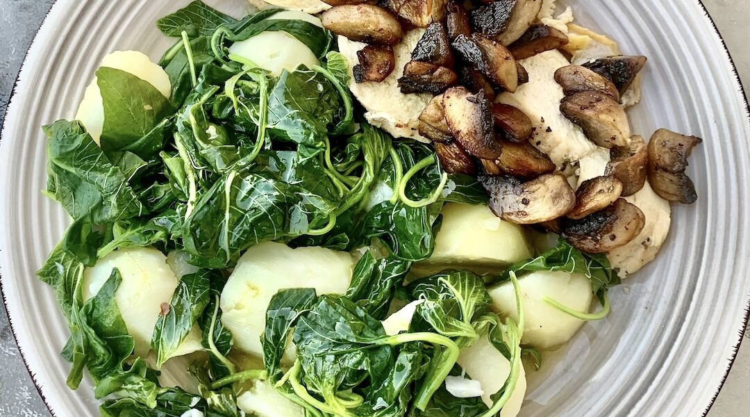 Pierś kurczaka pieczona w piekarniku, a następnie krojona w plastry i podana ze smażonymi pieczarkami oraz ziemniakami i szpinakiem.