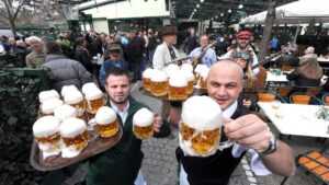 Kelnerzy z piwem w ręku w ogórku piwnym Schweizerhaus