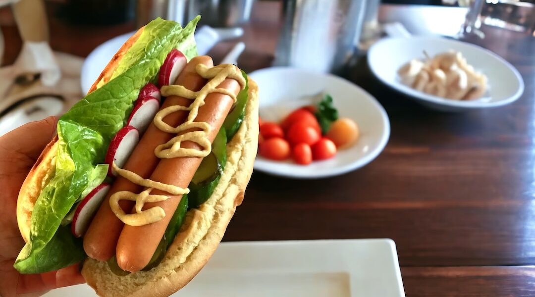 Domowy hot dog z parówkami sałatą ogórkiem i rzodkiewką