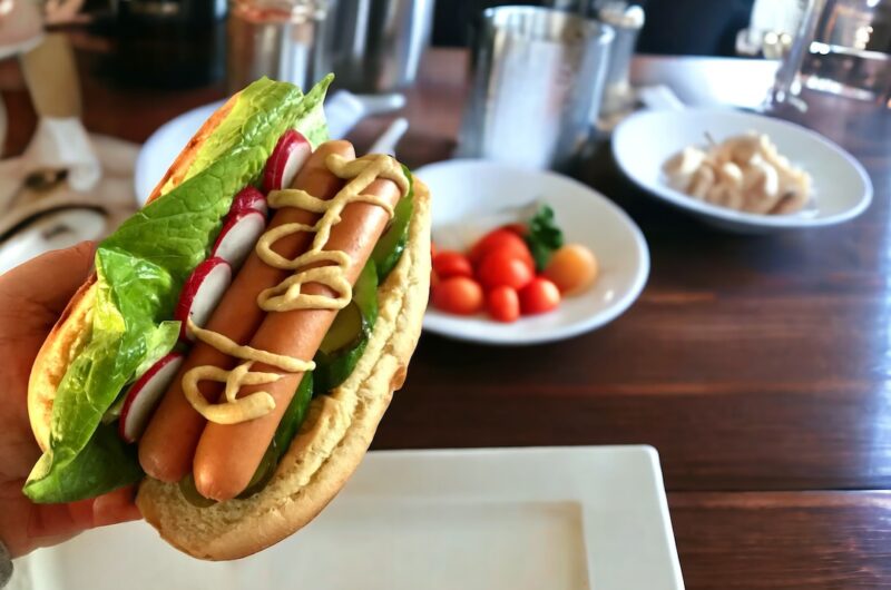 Domowy hot dog z parówkami sałatą ogórkiem i rzodkiewką
