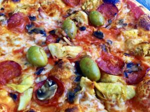 Pizza z salami, karczochami, oliwkami i pieczarkami