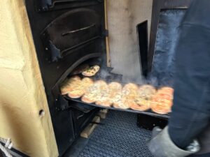 podpłomyk z Alzacji czyli flammkuchen wyjmowany z pieca na tacy