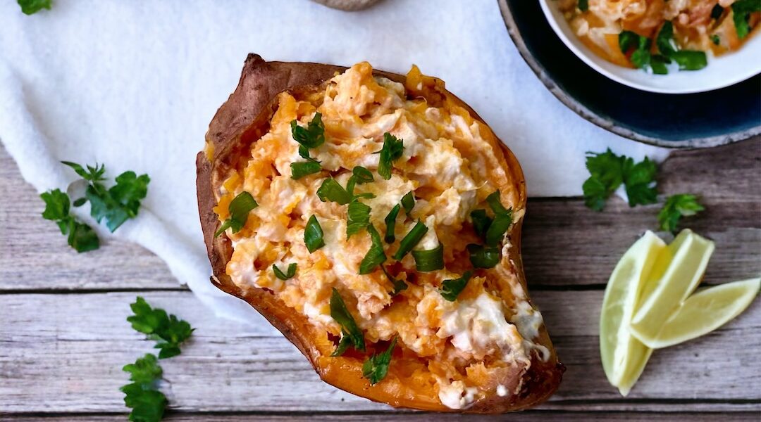 bataty z piekarnika przekrojone wzdłuż na połowę i wypełnione serem śmietankowym i serem feta