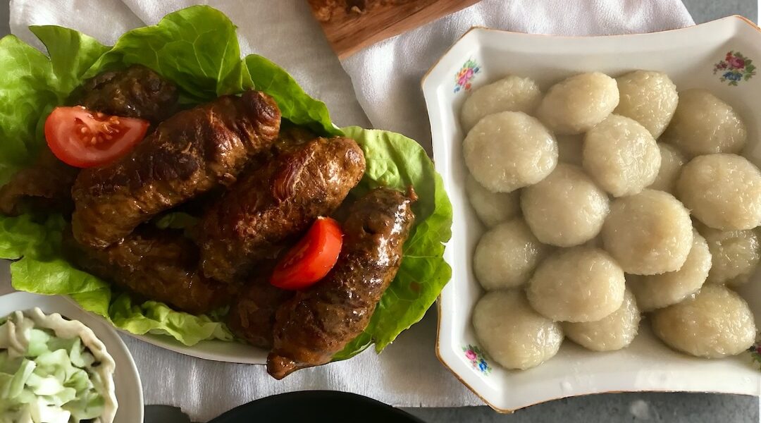 Rolady wieprzowe, czerwona i biała kapusta i kluski, czyli prawdziwy, obfity obiad podany na dużym stole.