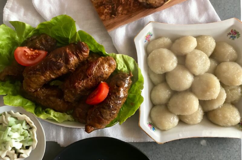 Rolady wieprzowe, czerwona i biała kapusta i kluski, czyli prawdziwy, obfity obiad podany na dużym stole.