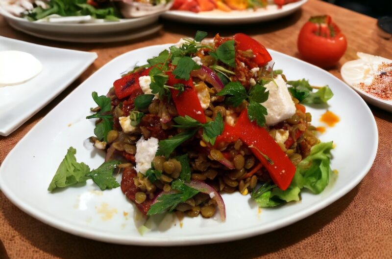 Sałatka z soczewicy i fety z dodatkiem czerwonej papryki i suszonych pomidorów na dużym talerzu