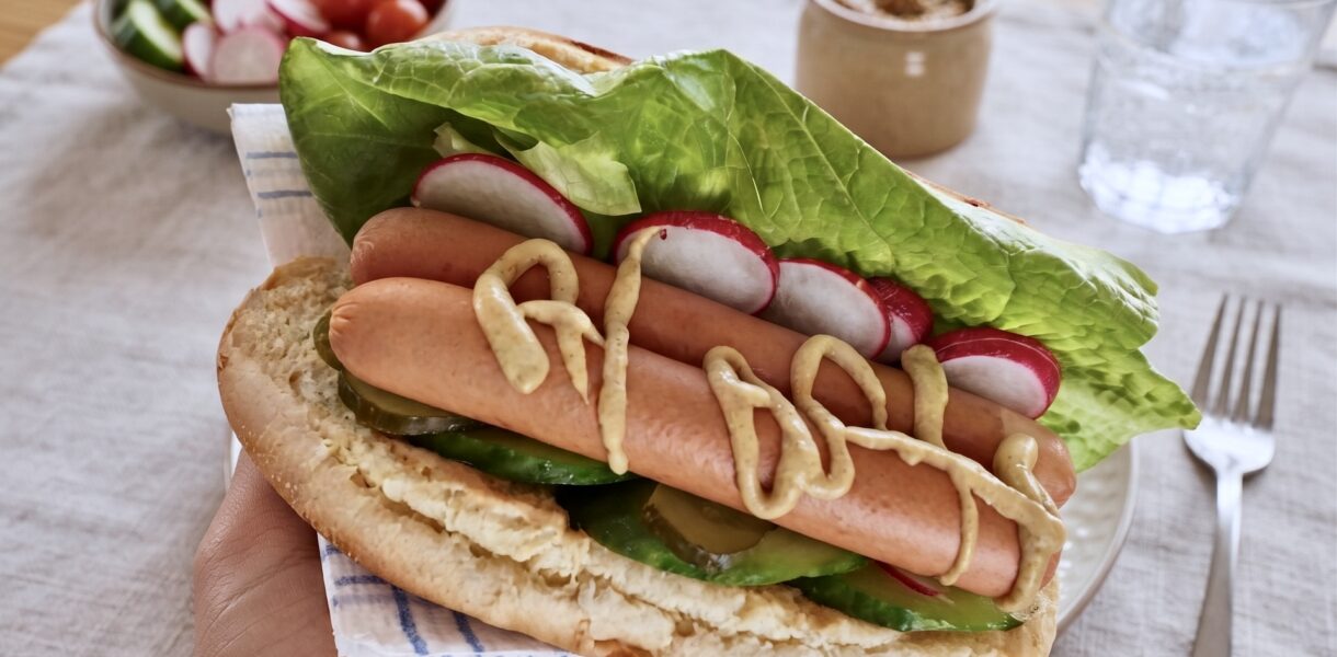 Domowy hot dog z parówkami sałatą ogórkiem i rzodkiewką