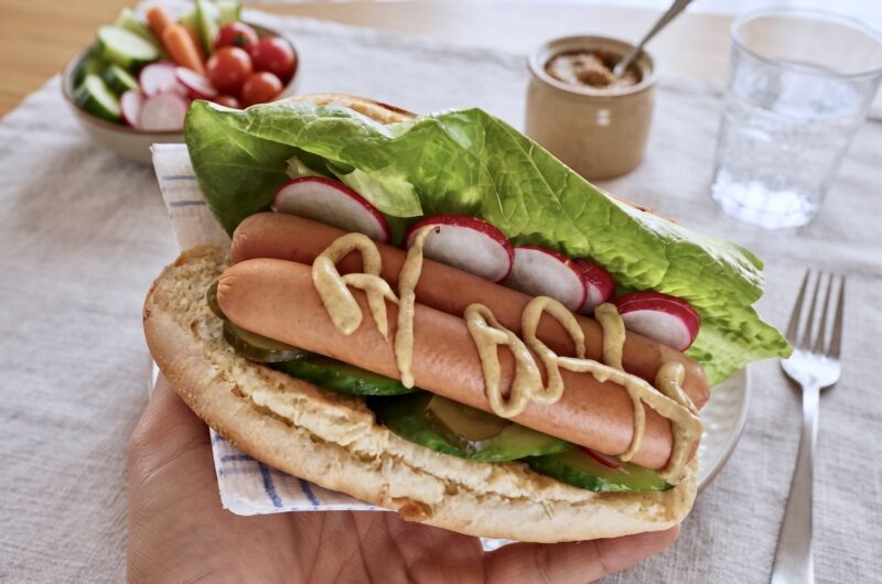 Domowy hot dog z parówkami sałatą ogórkiem i rzodkiewką