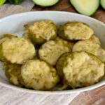 cukinia pokrojona w plastry, obłożona startym serem i czosnkiem, a następnie krótko zapiekana