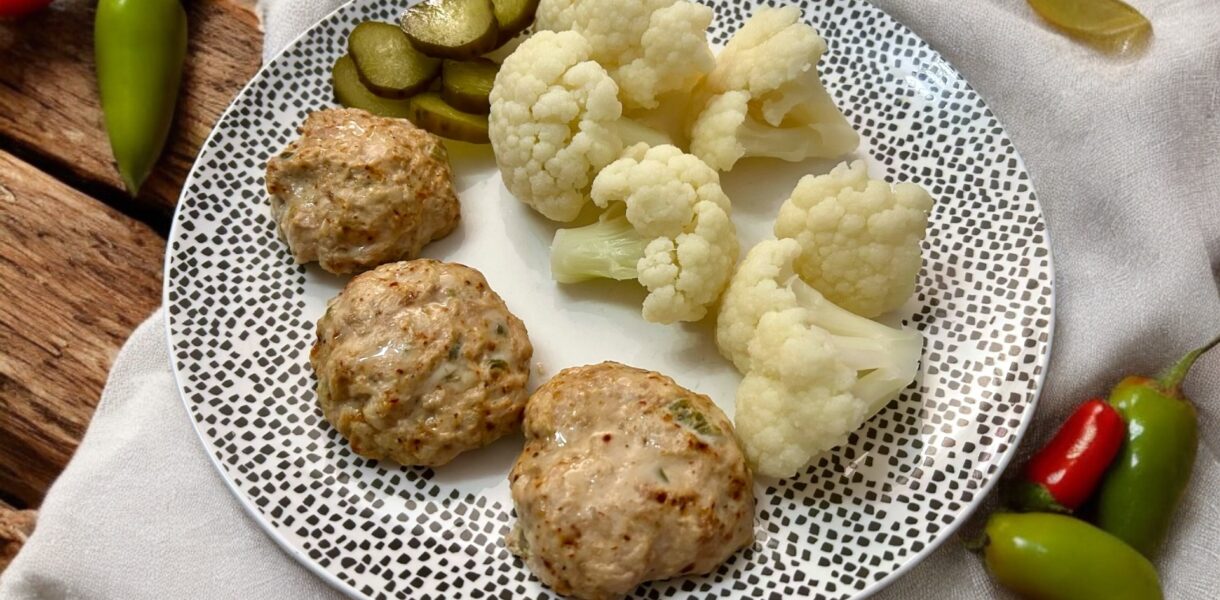 kotleciki z kurczaka mielonego z papryczką jalapeno podane na talerzu razem z różyczkami kalafiora