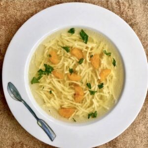 rosół drobiowy z makaronem nitki na talerzu