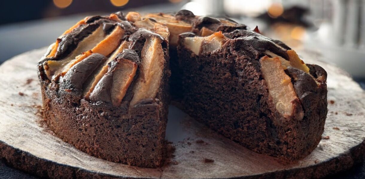 ciasto czekoladowe z gruszkami położone jest drewnianym półmisku