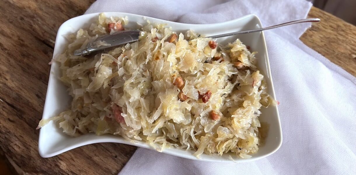 kiszona kapusta z boczkiem i cebulą na półmisku na stole