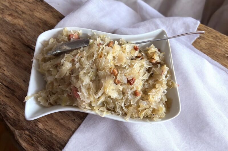 kiszona kapusta z boczkiem i cebulą na półmisku na stole