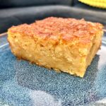 portokalopita greckie ciasto pomarańczowe przyrządzane z ciasta filo z dodatkiem pomarańczy i soku pomarańczowego na niebieskim talerzu