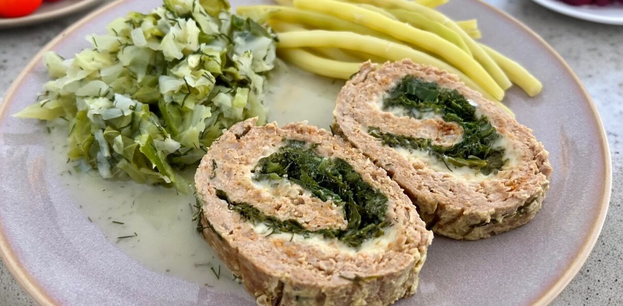 meatloaf z ziołami na talerzu podany z żółtą fasolką szparagową i młodą kapustą zasmażaną