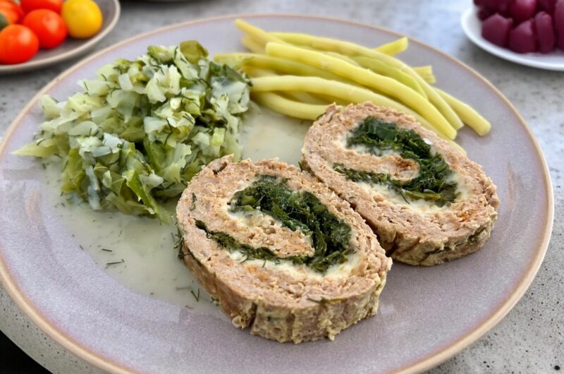 meatloaf z ziołami na talerzu podany z żółtą fasolką szparagową i młodą kapustą zasmażaną