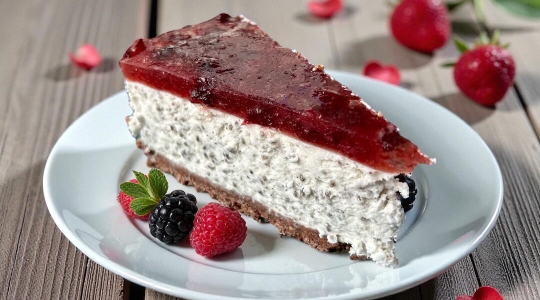 sernik chia z musem owocowym kawałek na talerzu obok świeże maliny i borówki