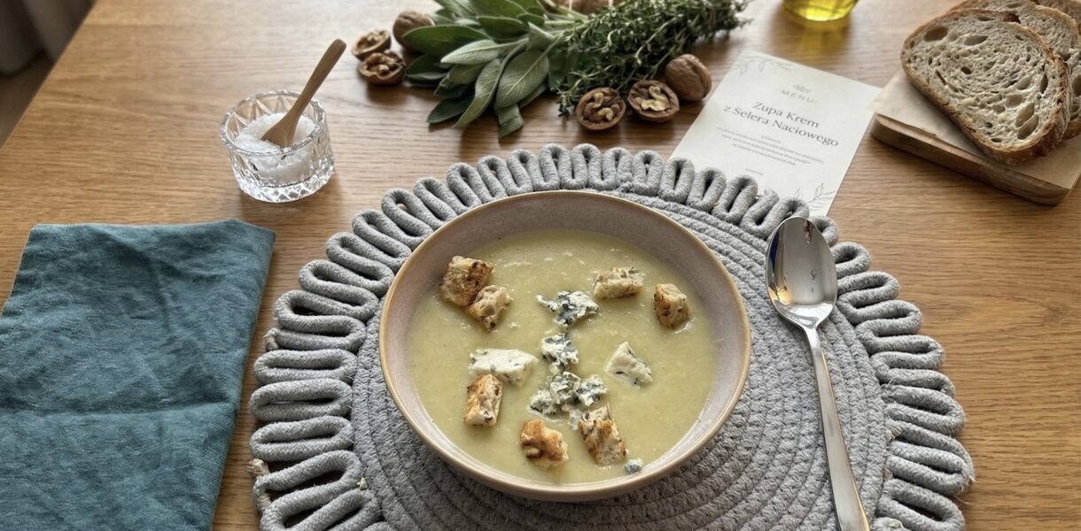 zupa krem z selera naciowego podana w misce razem z grzankami oraz kawałkami sera pleśniowego
