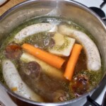 w dużym garnku gotują się warzywa oraz biała kiełbasa na żurek
