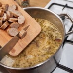 do żurku wrzucana jest pokrojona ugotowana biała kiełbasa