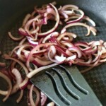 na patelni smaży się pokrojona w piórka czerwona cebula