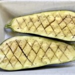 dwie połówki bakłażana w naczyniu żaroodpornym