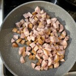 na patelni smaży się kiełbasa pokrojona w kostkę