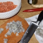 na desce kuchennej siekane są surowe krewetki