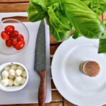 caprese składniki czyli pomidorki koktajlowe, świeża bazylia, małe mozzarelki