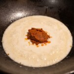 w woku gotuje się mleczko kokosowe z pastą curry