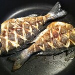 na patelni smażą się dwie ryby dorady