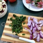 pokrojona czerwona cebula i natka pietruszki na desce kuchennej