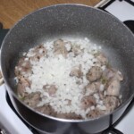 w garnku smażą się kawałki mięsa i cebuli