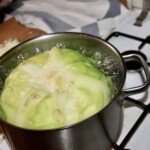 w dużym garnku gotuje się cała główka białej kapusty