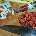 kiełbasa węgierska krojona na plastry na dece kuchennej