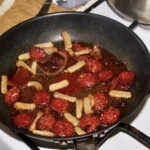 na patelni smaży się kiełbasa w plastrach oraz kawałki słoniny