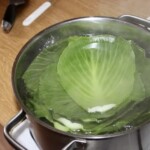 w garnku blanszują się liści białej kapusty