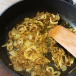 na patelni smaży się posiekana w piórka cebula wraz z pastą z przyprawami orientalnymi