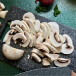 pokrojone w plasterki pieczarki na desce kuchennej