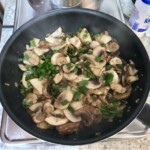 na patelni smażą się pokrojone w plasterki pieczarki