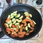 na patelni smażą się małe kawałki marchewki i cukinii