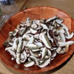 świeże grzyby pokrojone leżą w dużej drewnianej misce