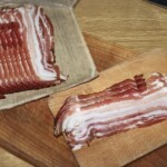 plastry boczku leżą na desce kuchennej
